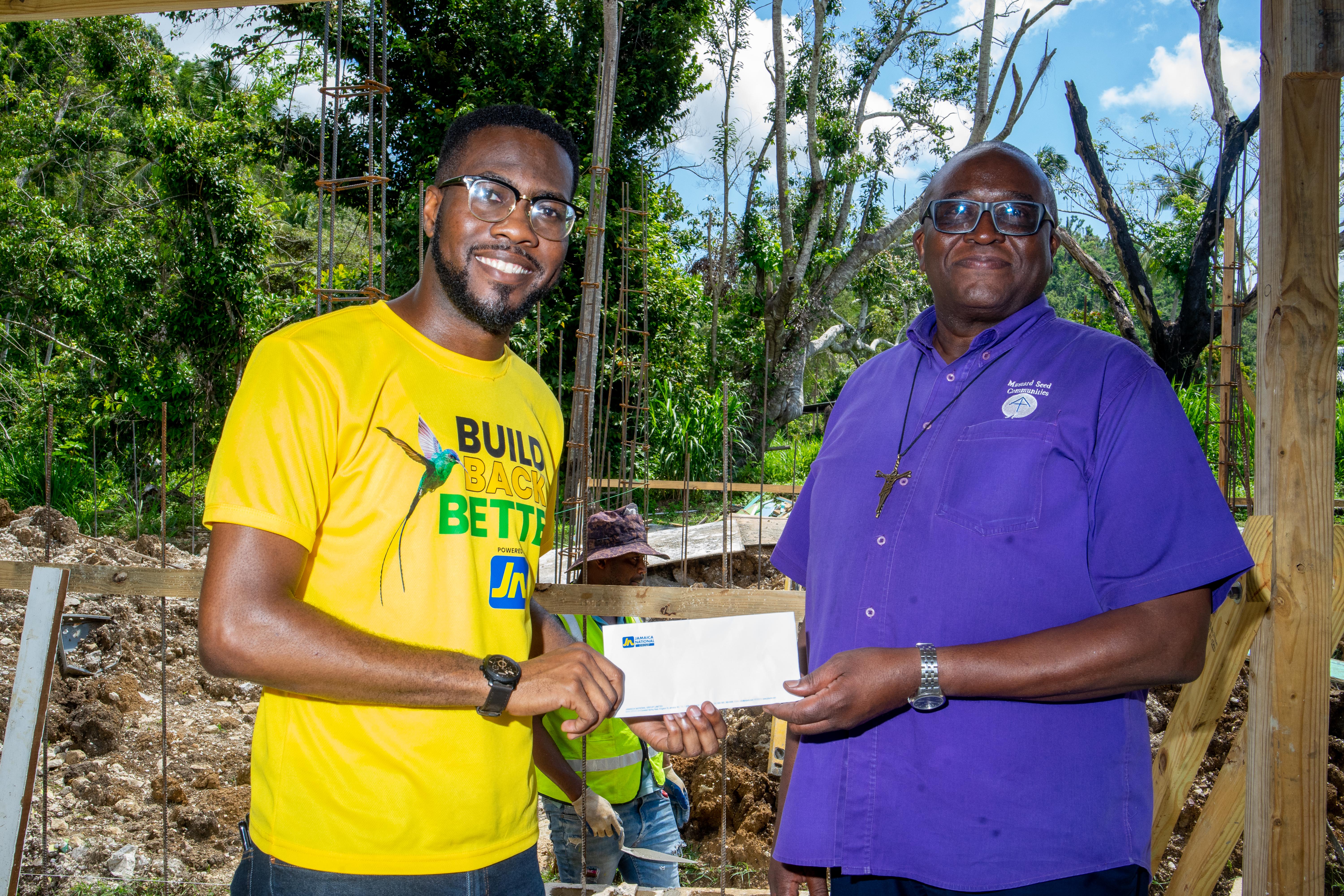 Omar Wright (left), lead, Environment and Community Development at the JN Foundation presents a cheque to Reverend Father Garvin Augustine, executive director of Mustard Seed Communities to carry out repairs to Blessed Assurance in St James, which was damaged by Hurricane Mellisa last year. The presentation was made recently at the mission.